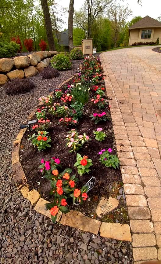 Driveway border garden with paver edging and boulder wall